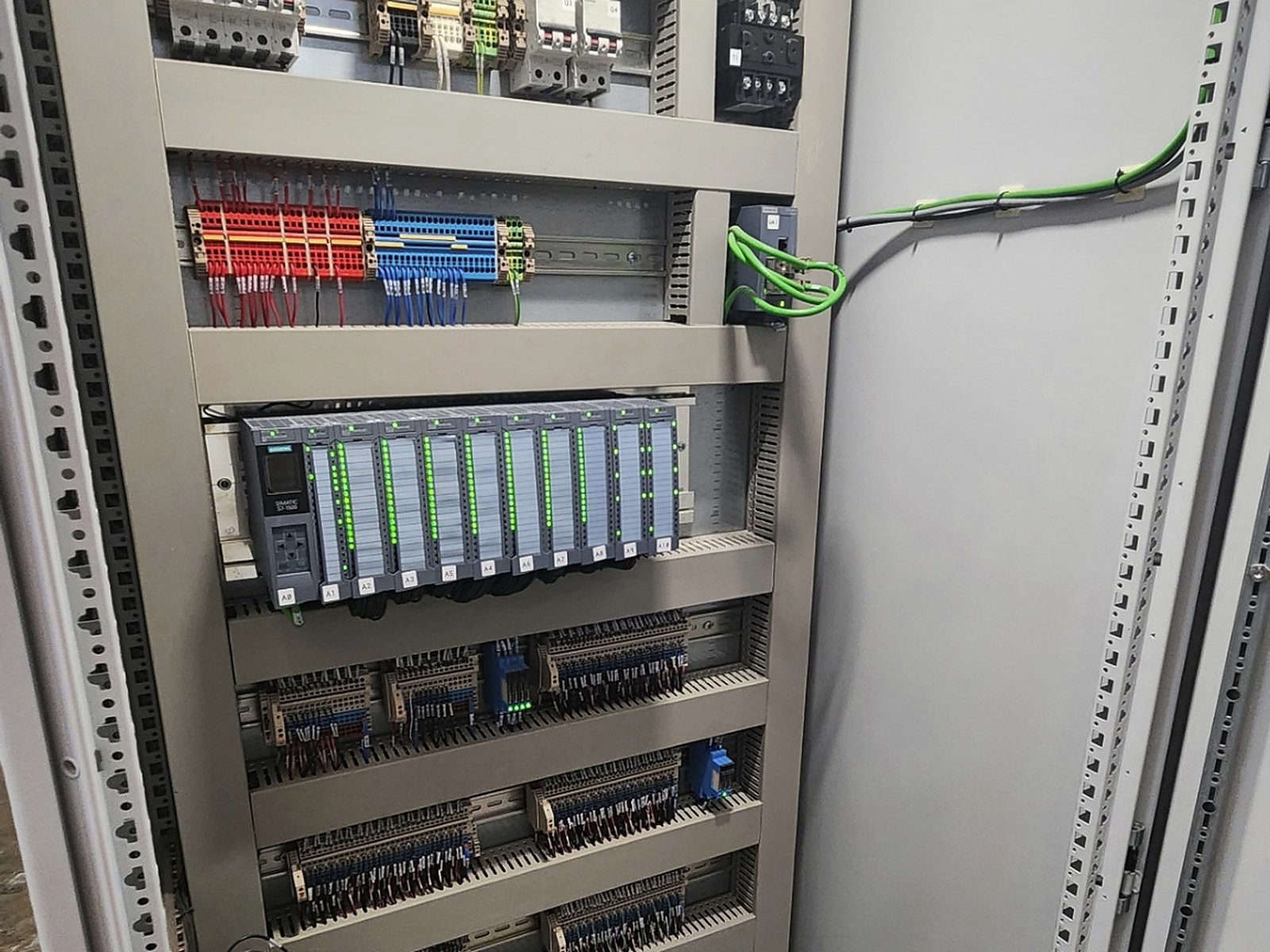 Tablero de automatización con fuente, PLC, módulos de entradas y salidas y borneras.